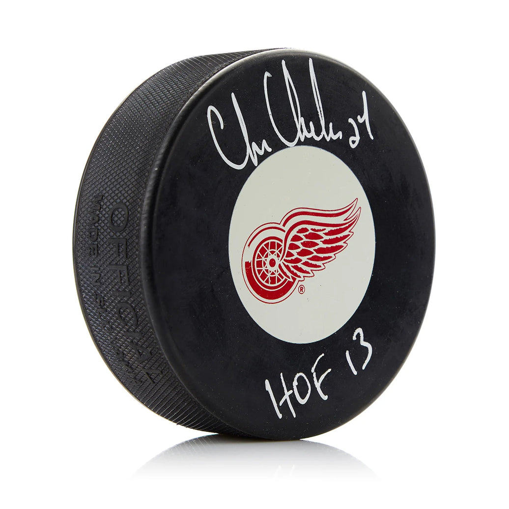 Disco firmado por los Detroit Red Wings por Chris Chelios con nota del Salón de la Fama